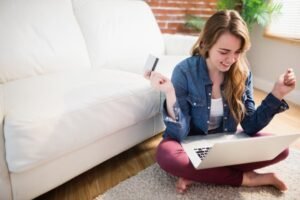 Jolie femme utilisant sa carte de crédit pour acheter en ligne